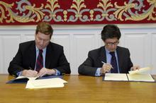 El presidente del Parlamento (izq) y del director territorial de la Caixa durante la firma del convenio