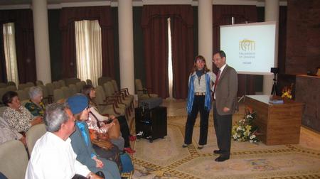 El Presidente del Parlamento, Antonio Castro Cordobez y la diputada de Coalición Canaria, Flora Marrero, saludan a los miembros de la Asociación de Vecinos Tuhoco, en el Salón de Actos