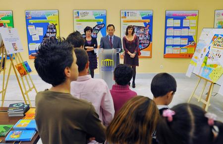 El presidente del Parlamento les habla a los niños que exponen sus trabajos.