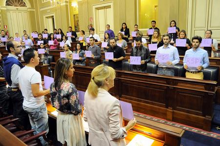 Los jóvenes muestran cartulinas con las iniciales de las víctimas.