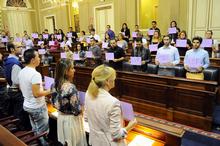 Los jóvenes muestran cartulinas con las iniciales de las víctimas.