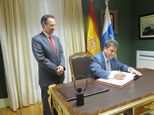 El embajador de Cuba firma en el libro de honor.