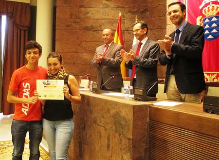 Dos representantes de los alumnos premiados recogen el diploma.