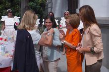 Representantes de Cruz Roja ponen la pegatina de la ONG a la presidenta.