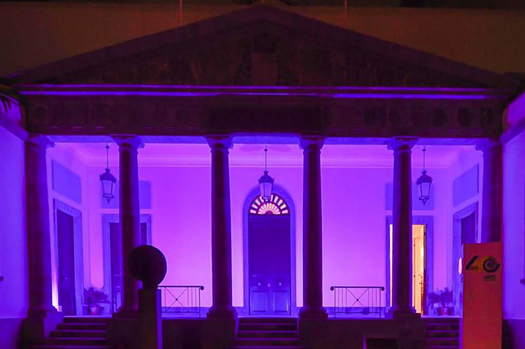 La fachada del Parlamento de Canarias iluminada de violeta